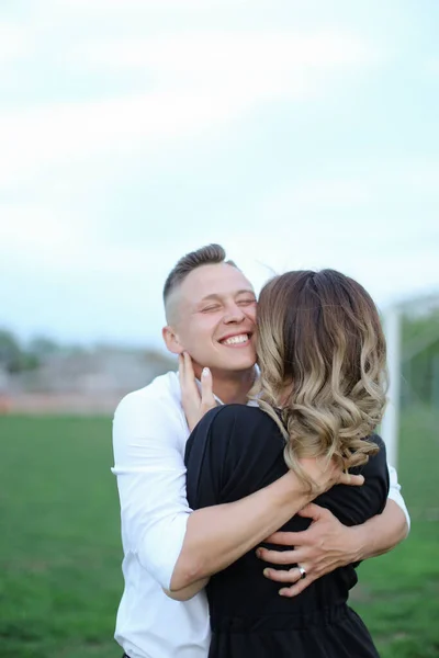 Portrait of young man hugging back view girl on football field. — Stock Photo, Image