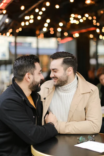 Caucásicos gays sentado en la cafetería, hablando y abrazando. — Foto de Stock