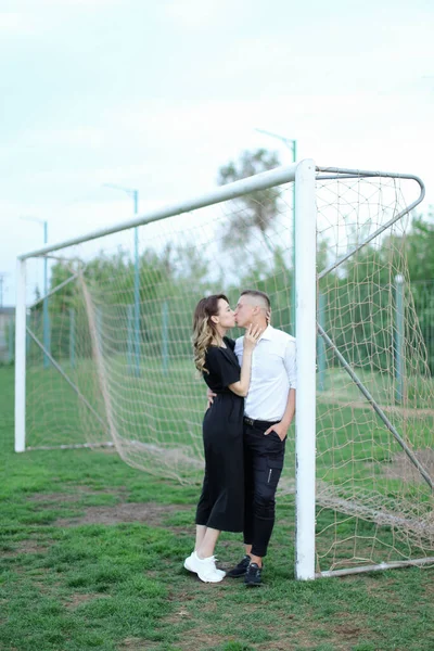Fiatal nő csók férfi futball kapu. — Stock Fotó
