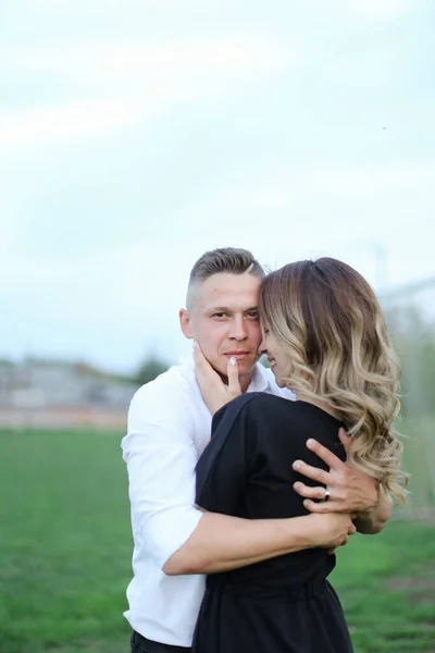 Portrait of caucasian man hugging back view girl on football field. — Stock Photo, Image