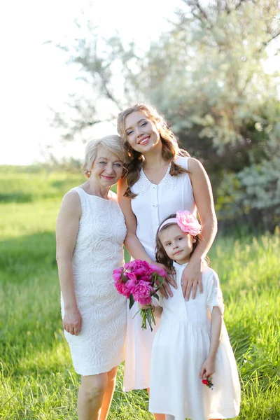 Jovem mulher de pé com mãe e filha fora. — Fotografia de Stock