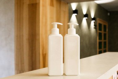 Beyaz plastik şişeler ve vücut kremi.