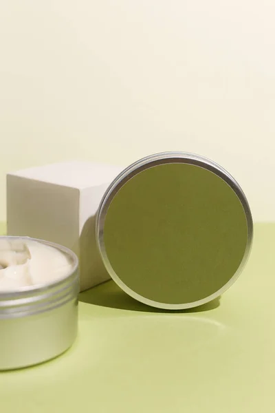 Crema blanca en lata redonda de aluminio sobre fondo neutro. Producto cosmético natural. Cuidado de la piel facial y corporal, productos cosméticos. — Foto de Stock