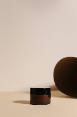 Nötr ışık arka planında izole edilmiş kremalı ve kapaklı plastik kavanoz. Güzellik merkezi ve cilt ürünleriyle ilgilenmek.