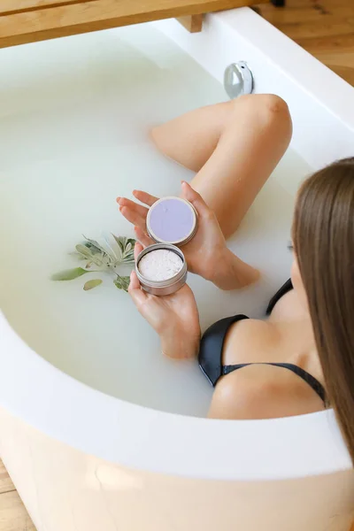 Vue du dessus des mains de la femme avec du savon solide sur fond d'eau blanche, prenant un bain — Photo