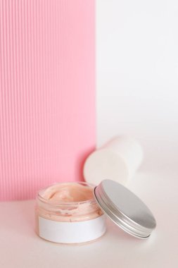 Nemlendirici kozmetik krem, sütün sıçramasıyla nötr bir zeminde durur.