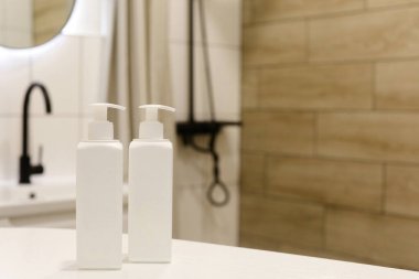 Beyaz plastik şişeler ve vücut kremi.