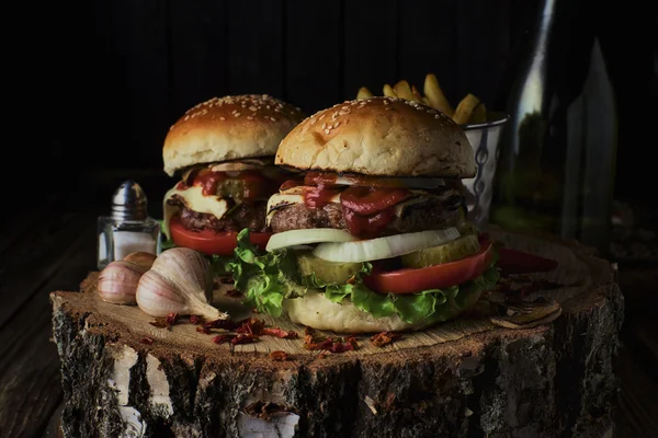 Dois hambúrgueres de carne em um fundo escuro . — Fotografia de Stock