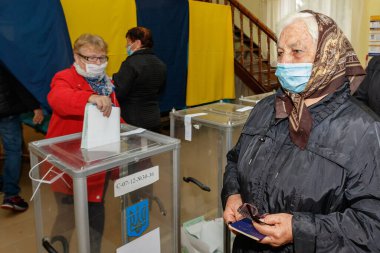 Velyka Dobron, Ukrayna - 25 Ekim 2020: Korunaklı maskeli seçmenler koronavirüs salgını sırasında yerel seçimlerde oy kullandılar.