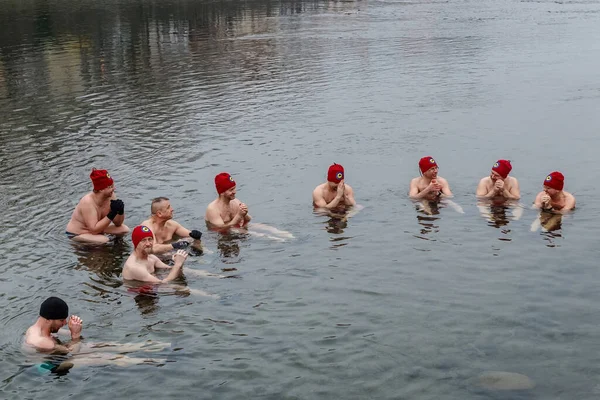 Uzhgorod, Ukrayna - 19 Ocak 2020: Bir grup insan Ukrayna 'daki geleneksel Epifani kutlamaları sırasında buzlu nehirde banyo yapıyor.