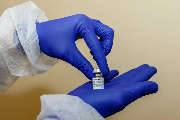 COVID-19 'a karşı Pfizer aşısı bir doktorun elinde. Doktorun elinde bir şişe Coronavirus aşısı var. Koronavirüs salgını sırasında aşılanma kavramı.