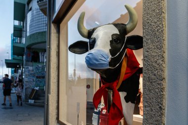 Porto, Portekiz - 7 Eylül 2021 Porto, Portekiz şehir merkezindeki bir dükkanın önünde maskeli bir ineğin heykeli.