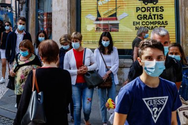 Porto, Portekiz - 11 Eylül 2021: Koruyucu maskeli bir grup insan Porto, Portekiz 'in merkezinde karşıdan karşıya geçiyor.