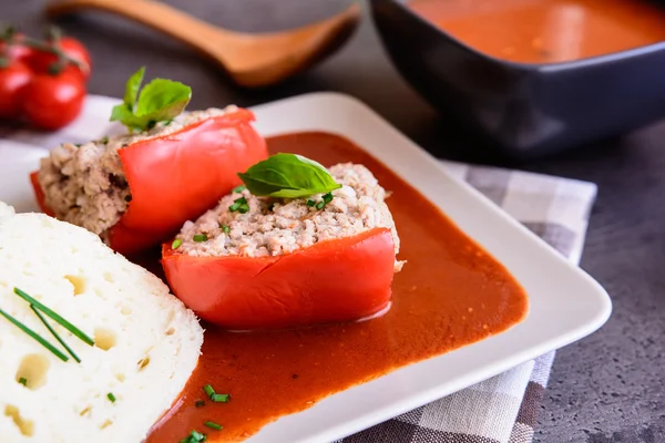 Rød peber fyldt med ris, hakket kød og grøntsager i tomatsauce - Stock-foto