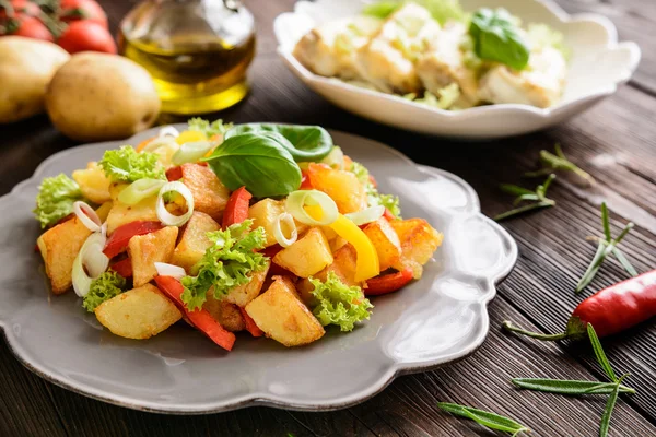 Salada de batata frita com alface, pimenta, cebola e filetes de peixe assados cobertos com queijo — Fotografia de Stock