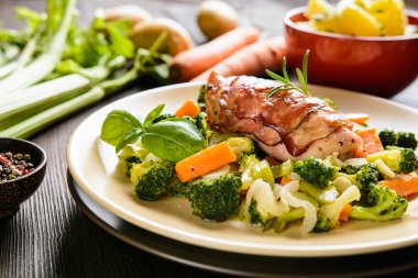 Fırında tavuk göğsü pastırma haşlanmış patates ile sarılmış ve haşlanmış sebze garnitür