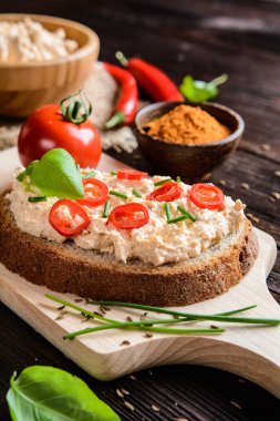 Biber, zemin kimyon, frenk soğanı ve fesleğen ile kremsi lor yayıldı