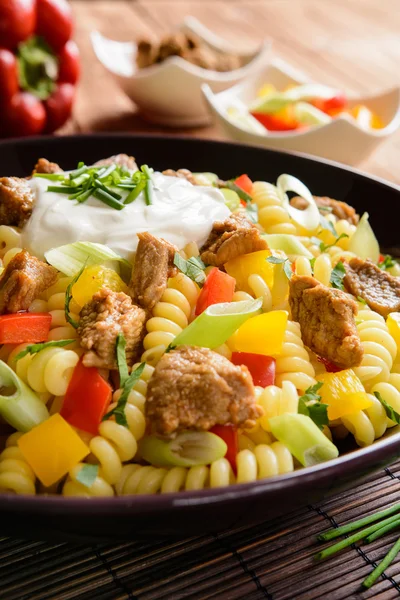 Ensalada de pasta con cerdo, pimienta, cebolla verde, perejil y crema agria — Foto de Stock