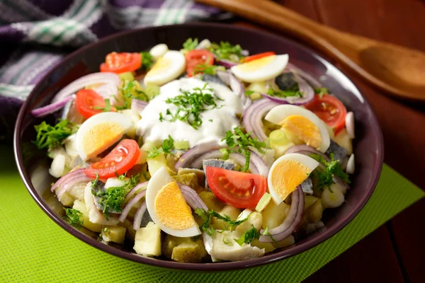 Salată de pește cu cartofi, ouă, ceapă roșie, roșii și dressing — Fotografie, imagine de stoc