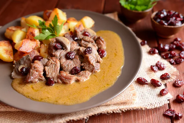 Vildsvinskött med rostad potatis, svamp och tranbär — Stockfoto