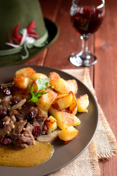 Vildsvinskött med rostad potatis, svamp och tranbär — Stockfoto