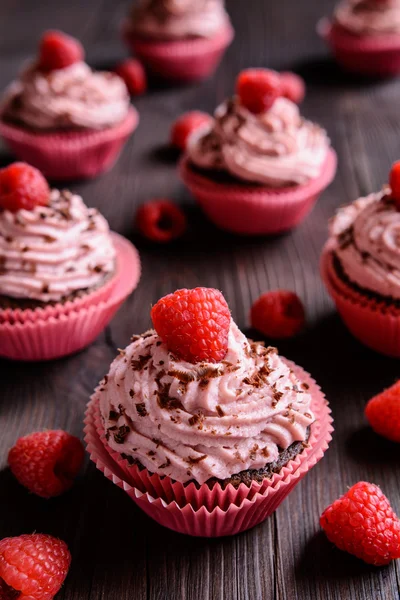 Cupcakes de frambuesa espolvoreados con chocolate sobre fondo oscuro —  Fotos de Stock