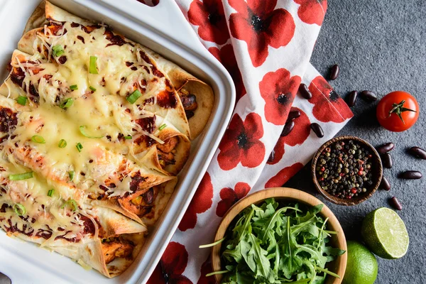 Chicken enchiladas with spicy tomato sauce, corn, beans and cheese — Stock Photo, Image