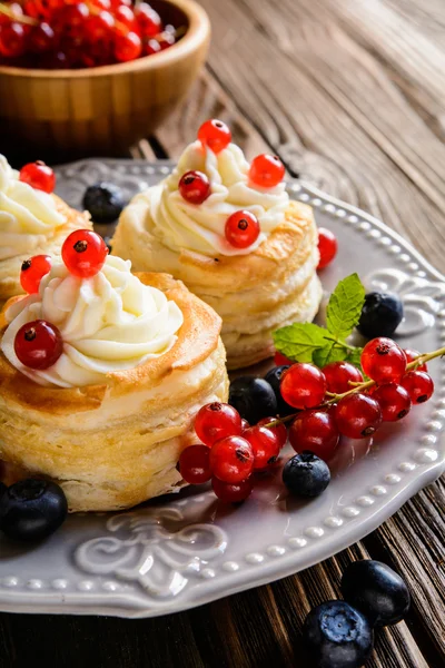 Puff pastry cakes filled with whipped cream and berries — Stock Photo, Image