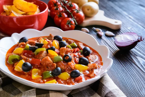 Ragu de cerdo con pimienta, aceitunas y papas fritas — Foto de Stock