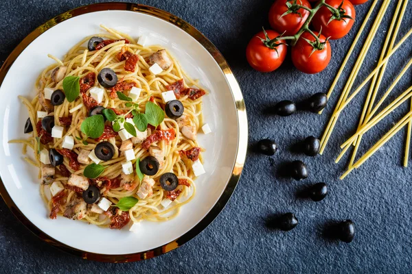 Pasta de espaguetis con carne de pollo, sol - tomate seco, aceitunas y queso Feta — Foto de Stock