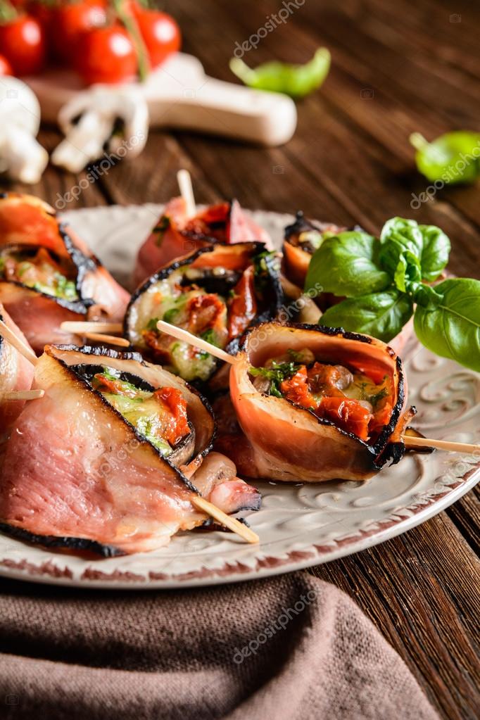 Pilze gefüllt mit Käse, sonnengetrockneten Tomaten und eingewickelt in ...