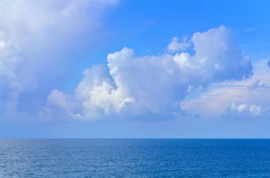 Kabarık beyaz, bulutlu gökyüzü parlak bir gün boyunca denize.