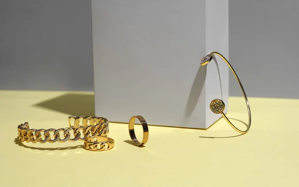Cadeia forma pulseiras douradas na superfície amarela — Fotografia de Stock