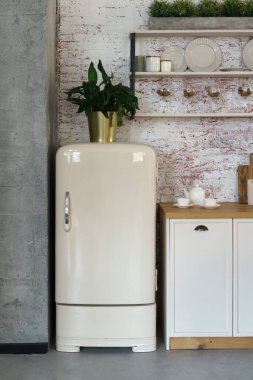 Tavan arası tarzı mutfaktaki eski moda buzdolabının ön manzarası