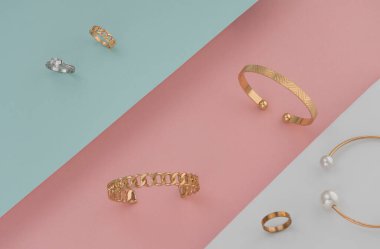 Pastel renklerde altın ve gümüş mücevherlerin yerleşimi