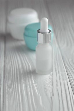 Boru şişesi ve krema kapları ahşap masada.