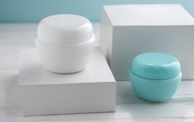 İki beyaz ve mavi krema kutusu ve boş beyaz kutu.