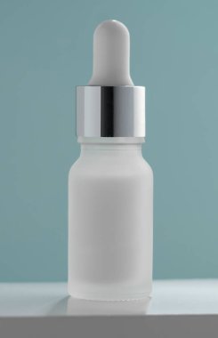 Yeşil arkaplandaki pipet şişesinin dikey görüntüsü