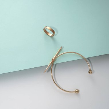 Mavi ve beyaz arkaplanda kopyalama alanı olan altın bilezik ve yüzük