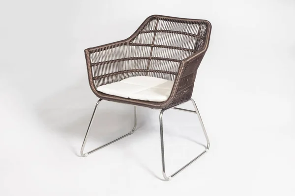 Коричневе плетіння сучасного відкритого крісла з металевими ніжками, ізольованими на білому тлі. — стокове фото