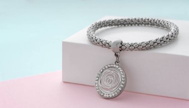 Pastel renklerde çiçek şekilli kolyesi olan gümüş bilezik.