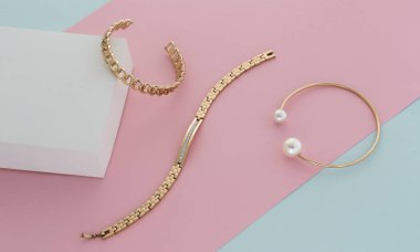 Pastel renkler üzerine altın modern bilezikler pembe mavi ve beyaz kağıt arka plan