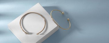 Modern bileziklerin panoramik görüntüsü mavi arka plandaki beyaz kutunun üzerinde kopyalama alanı ile