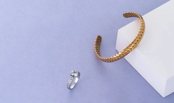 Nowoczesna złota bransoletka i diamentowy pierścionek na białym i niebieskim papierowym tle z przestrzenią do kopiowania — Zdjęcie stockowe