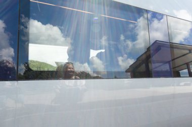 Woman saying goodbye to train passenger, reflections in window