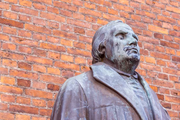 Bronze statue of reformer Martin Luther in front of brick wall — Stock Photo, Image