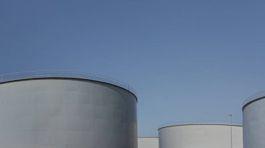 24 Ağustos 2017 'de Fredericia, Danimarka' da mavi gökyüzüne karşı dört büyük gri petrol sarnıcı.