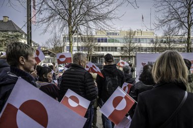 Protestocular, ABD 'nin Kopenhag Büyükelçiliği önünde 29 Mart 2025' te Grönland 'ı ziyaret eden Başkan Yardımcısı JD Vance' e karşı düzenlenen gösteriye katılırken bayraklar tutuyorlar.