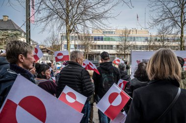 Protestocular, ABD 'nin Kopenhag Büyükelçiliği önünde 29 Mart 2025' te Grönland 'ı ziyaret eden Başkan Yardımcısı JD Vance' e karşı düzenlenen gösteriye katılırken bayraklar tutuyorlar.