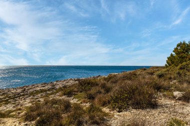 Spring landscape at Cape Kamenjak Croatia with turquoise water and small boats in sunlight